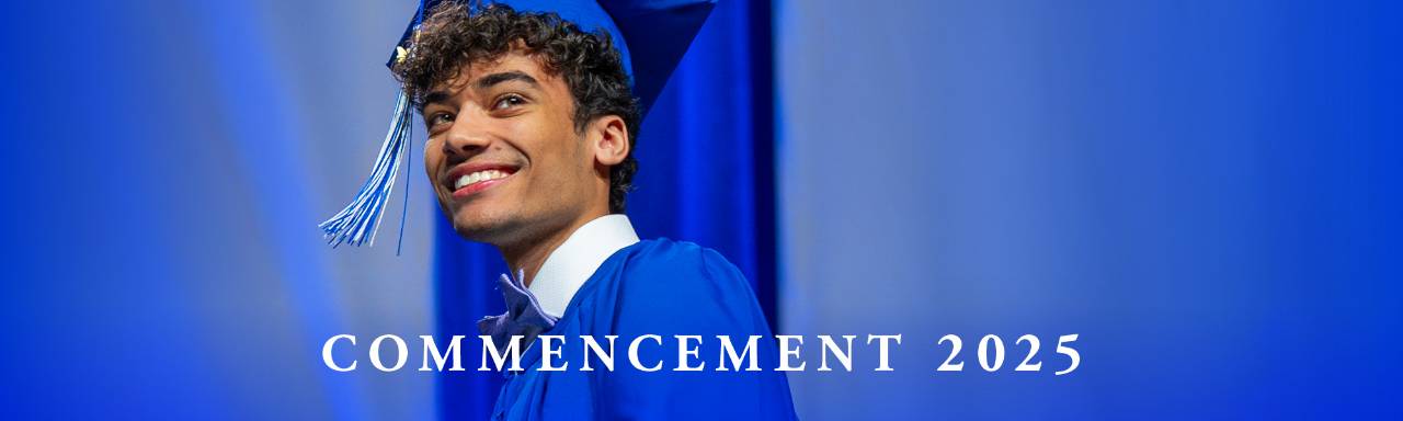 graduate smiling in blue cap and gown - Commencement 2025